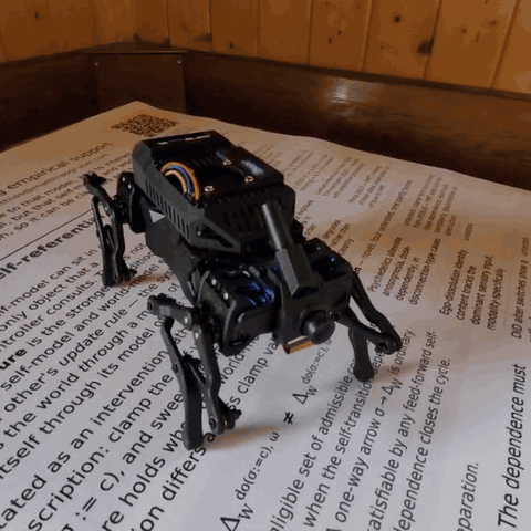 Quadruped robot walking across the printed MoC7 poster